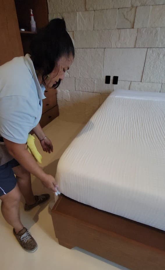 Qtana cleaner making a bed during a service