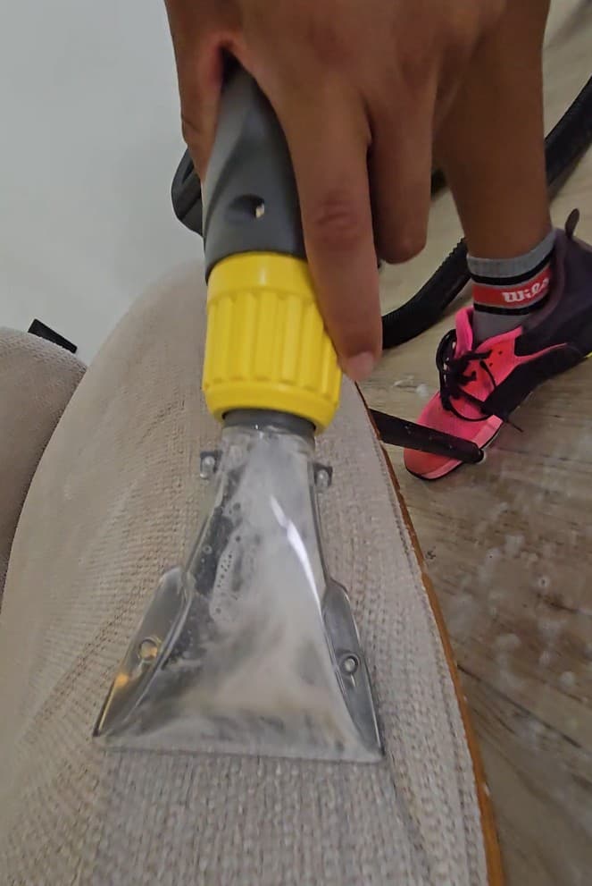 Qtana cleaner using an upholstery extraction tool on fabric